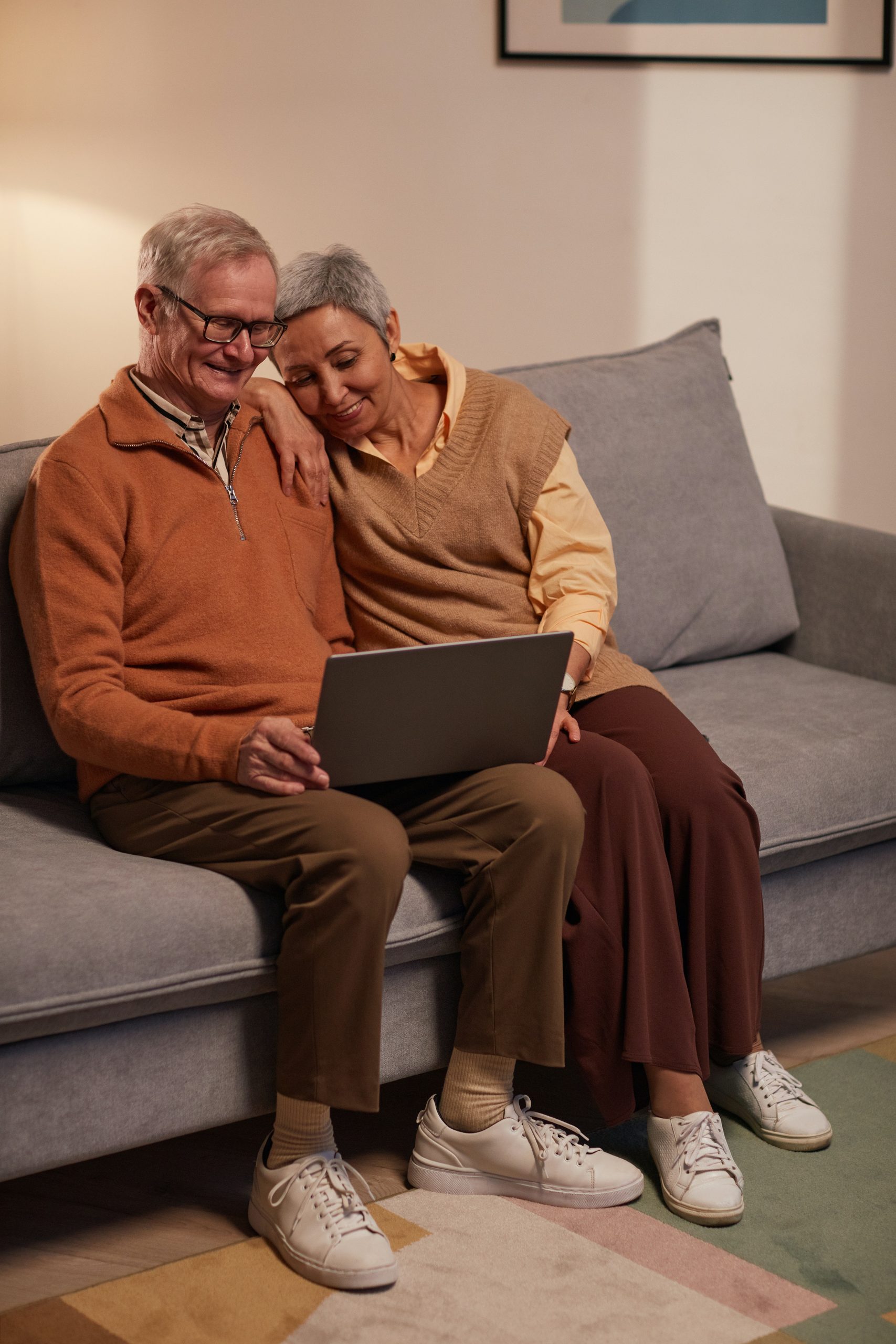 Man and woman sitting on sofa with computer